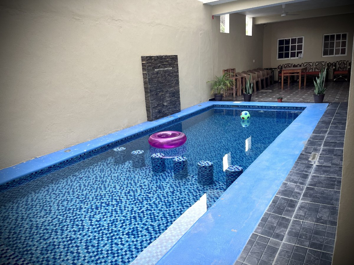 Alberca en bungalow con agua azul